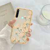 a woman holding a phone case with flowers on it