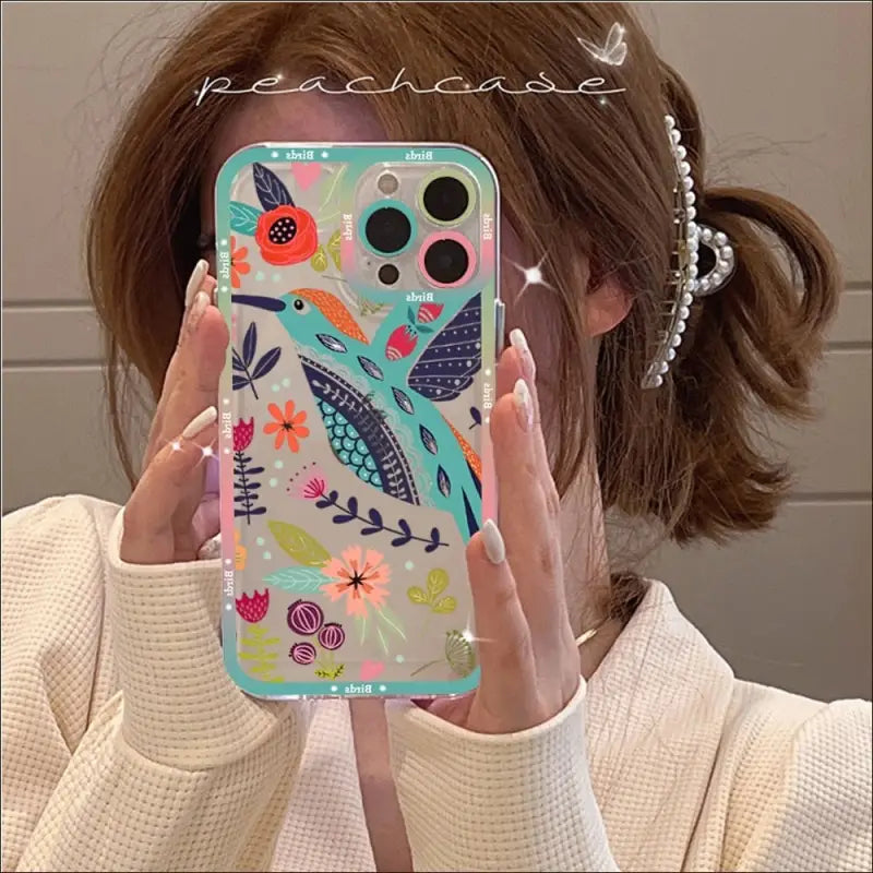 a woman holding up her phone case