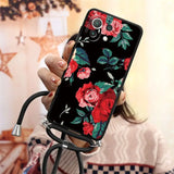 a woman holding a phone case with flowers on it