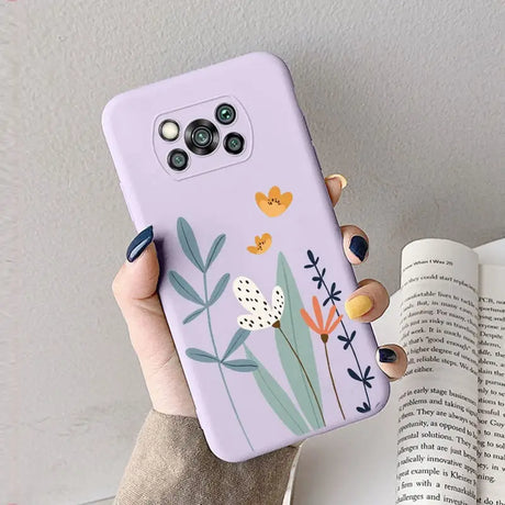 a woman holding a phone case with flowers on it