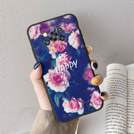 a woman holding a phone case with flowers on it