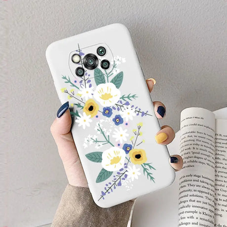 a woman holding a phone case with flowers on it