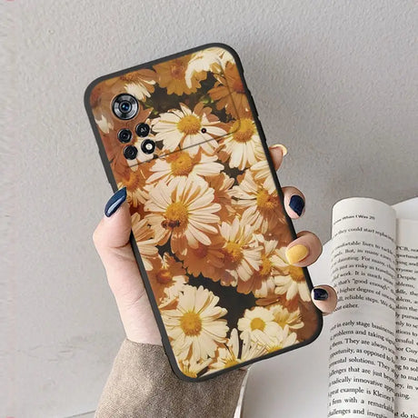 A woman holding a phone case with flowers on it