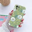 a woman holding a phone case with flowers on it