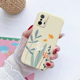 a woman holding a phone case with flowers on it