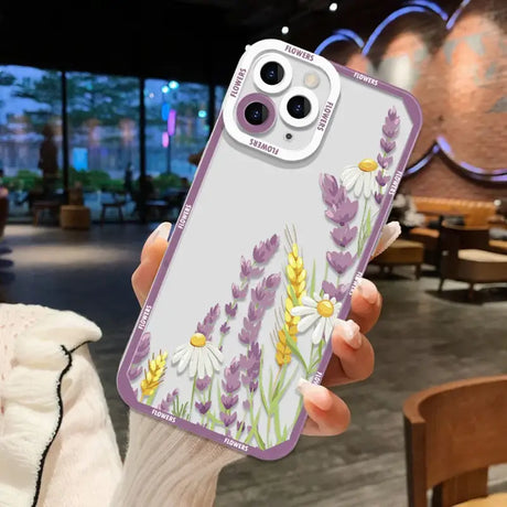 A woman holding up a phone case with flowers on it