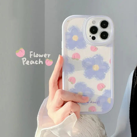 A woman holding a phone case with flowers on it