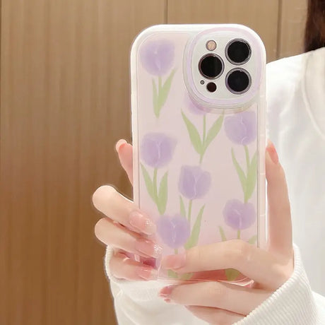 A woman holding a phone case with flowers on it