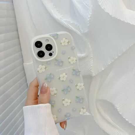 A woman holding a phone case with flowers on it