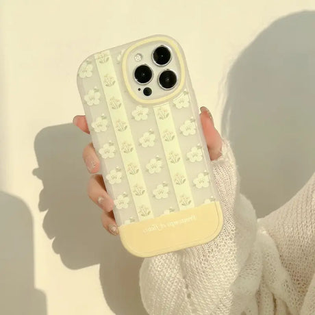 A woman holding a phone case with flowers on it