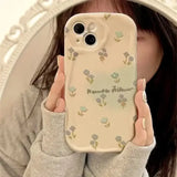 a woman holding a phone case with flowers on it