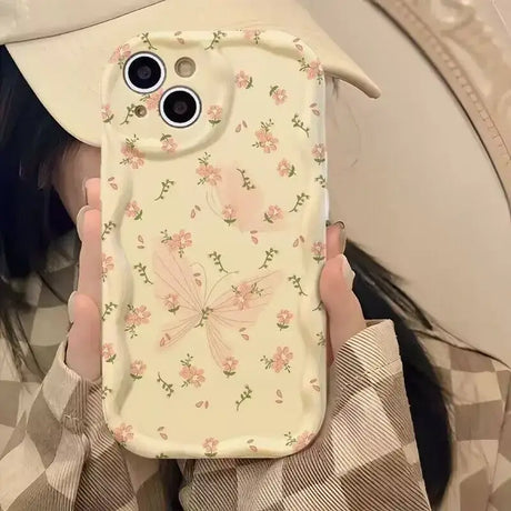 A woman holding a phone case with flowers on it