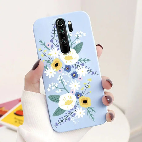 A woman holding a phone case with flowers on it