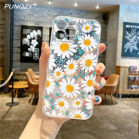 A woman holding up a phone case with flowers on it