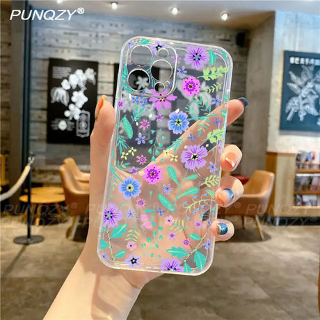 A woman holding a phone case with flowers on it