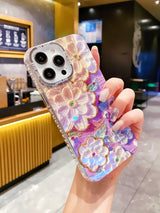 a woman holding a phone case with flowers on it