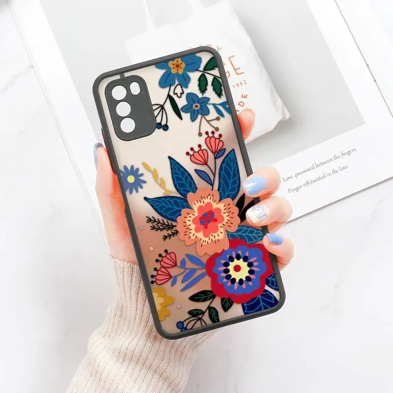 a woman holding a phone case with flowers on it