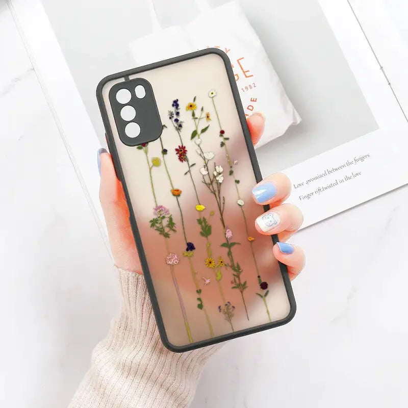 a woman holding a phone case with flowers on it