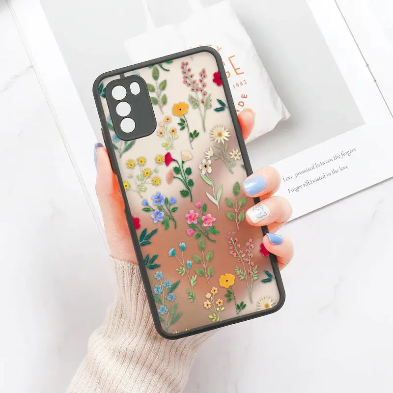 a woman holding a phone case with flowers on it