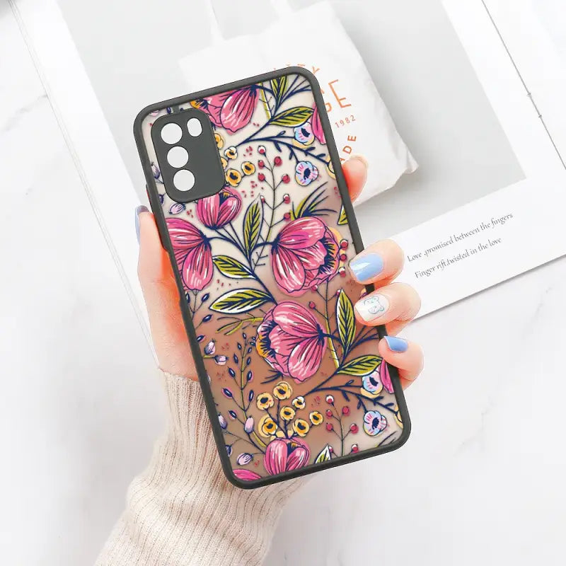 a woman holding a phone case with flowers on it