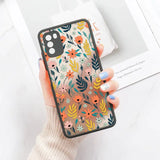 a woman holding a phone case with flowers on it