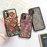 a woman holding a phone case with flowers on it