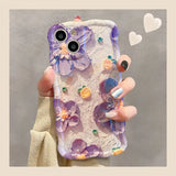 a woman holding a phone case with flowers on it