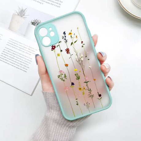 A woman holding a phone case with flowers on it