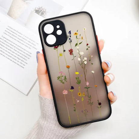 A woman holding a phone case with flowers on it