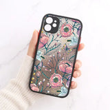A woman holding a phone case with flowers on it