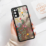 a woman holding a phone case with flowers on it