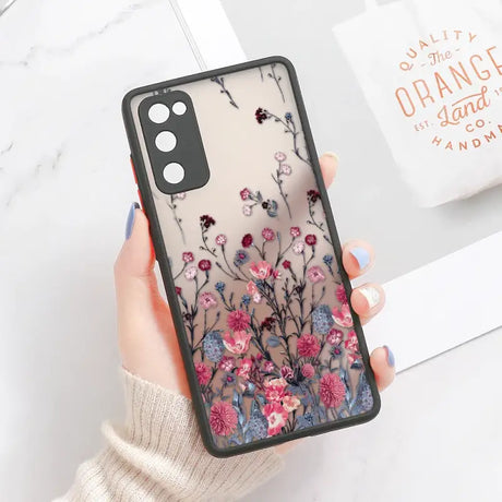 A woman holding a phone case with flowers on it