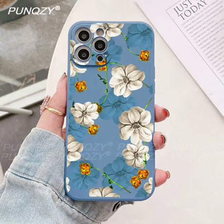 A woman holding a phone case with flowers on it