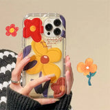 a woman holding a phone case with flowers on it