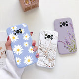 a woman holding a phone case with flowers on it
