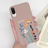 a woman holding a phone case with flowers on it