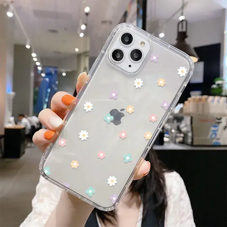 A woman holding up a phone case with flowers on it