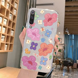 a woman holding a phone case with flowers on it