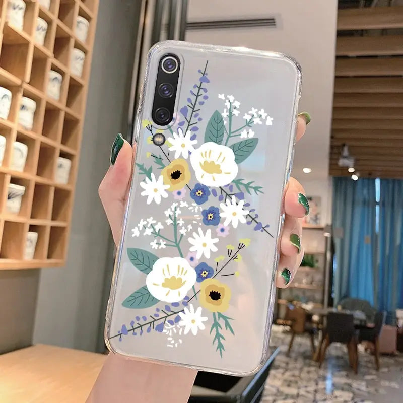 a woman holding a phone case with flowers on it