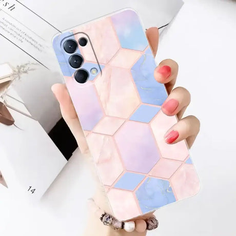 A woman holding a phone case with a geometric design