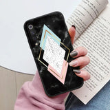 a woman holding a phone case with a geometric design