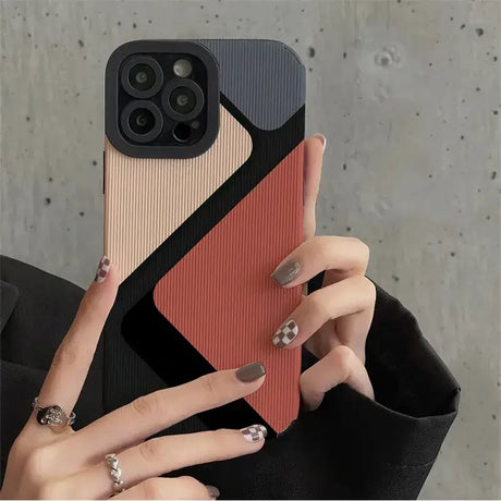 a woman holding a phone case with a geometric design