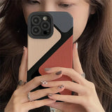 a woman holding a phone case with a geometric design