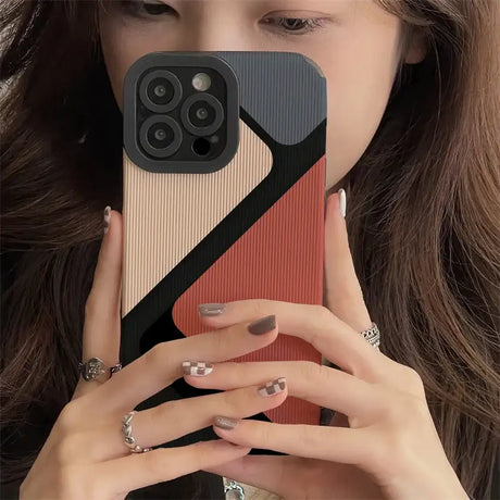 A woman holding a phone case with a geometric design