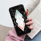 a woman holding a phone case with a geometric design