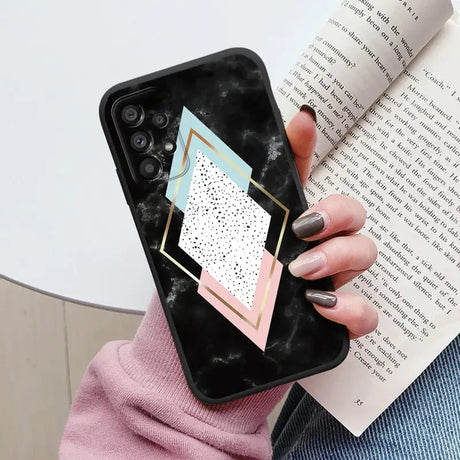 a woman holding a phone case with a geometric design