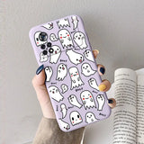 A woman holding a phone case with ghost pattern