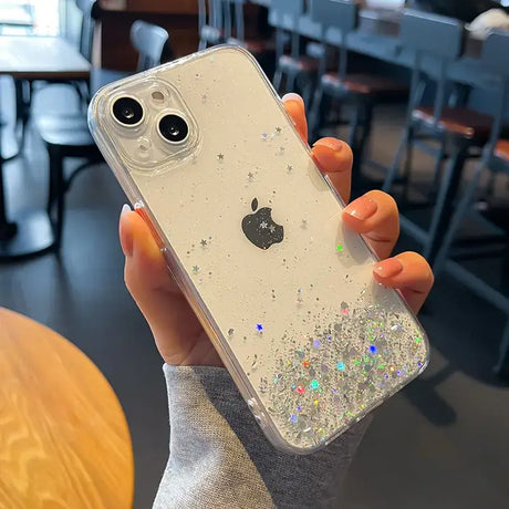 A woman holding a phone case with glitter on it