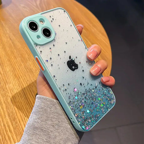 A woman holding a phone case with glitter on it