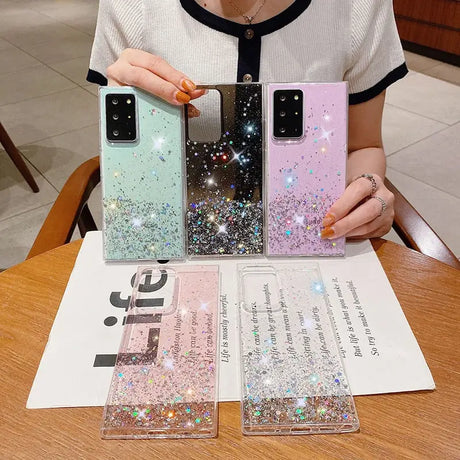 a woman holding a phone case with glitter